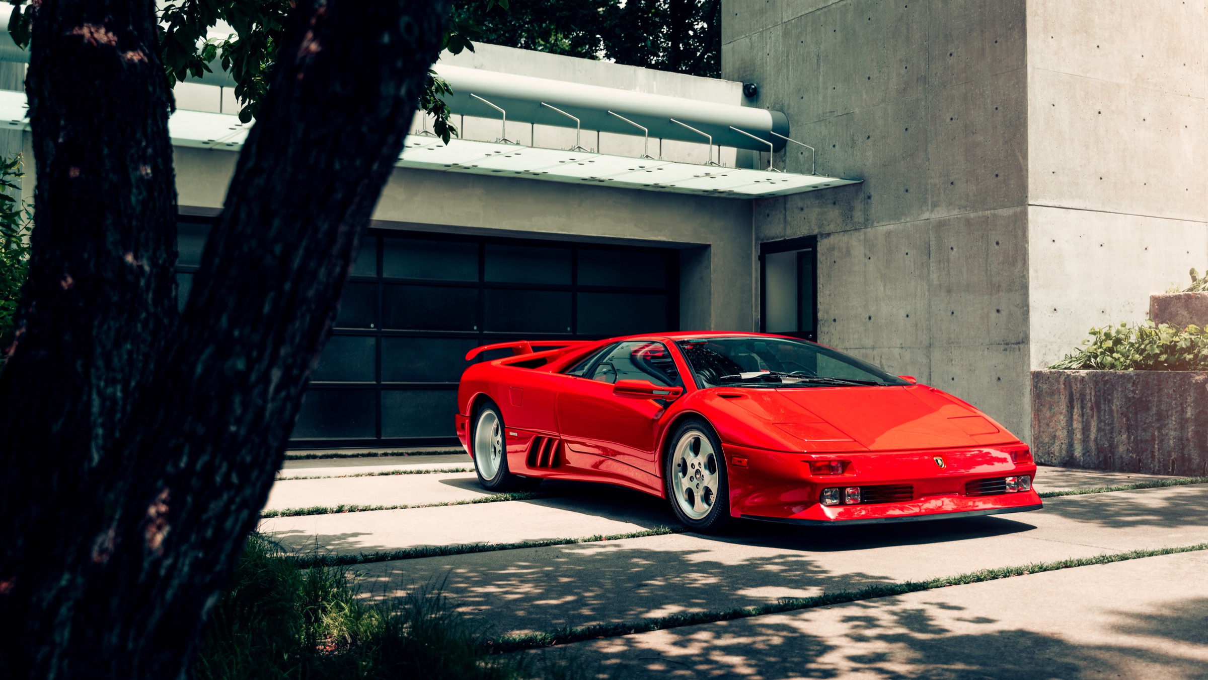 Red Lamborghini Diablo in front of brutalist architecture
