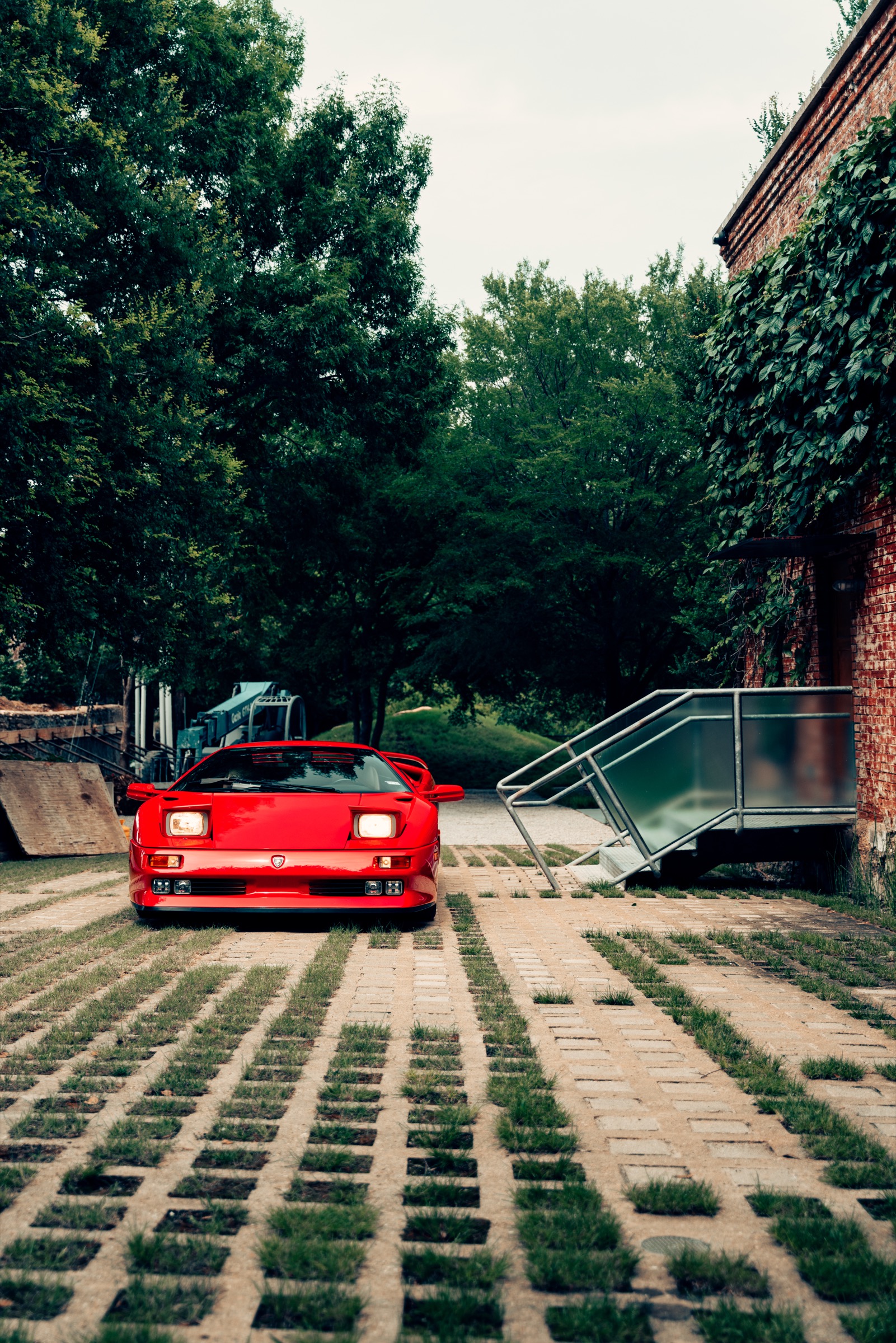 Lamborghini Diablo with scissor door open against brutalist concrete